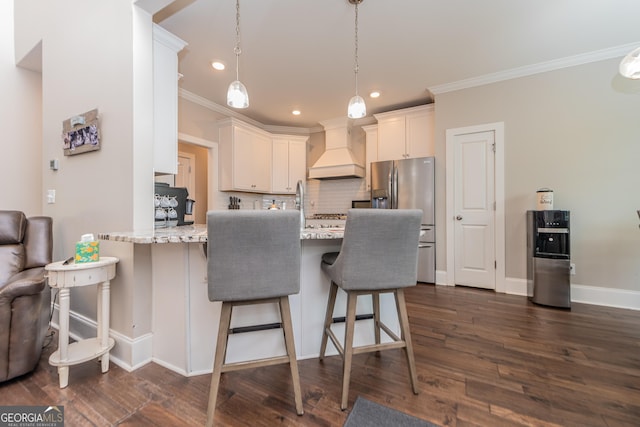 924 Abingdon Cv, Bonaire, GA 31005 - kitchen with premium range hood, stainless steel refrigerator with ice dispenser, ornamental molding, decorative backsplash, and a kitchen bar