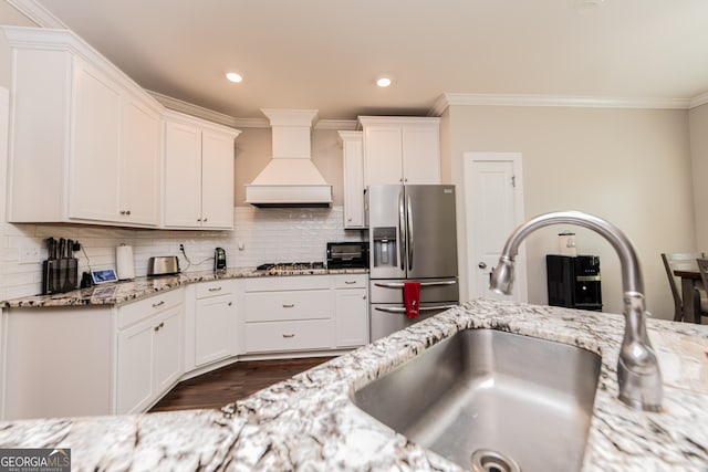924 Abingdon Cv, Bonaire, GA 31005 - kitchen featuring custom exhaust hood, appliances with stainless steel finishes, a sink, crown molding, and white cabinets