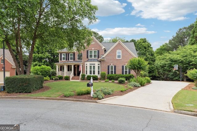 151 Overhill Pt, Alpharetta, GA 30005 - view of front of home with a front yard, brick siding, a standing seam roof, covered porch, and driveway