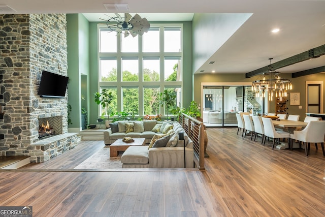 209 Voyles Way, Dawsonville, GA 30534 - living room with a chandelier, a towering ceiling, a fireplace, and wood finished floors