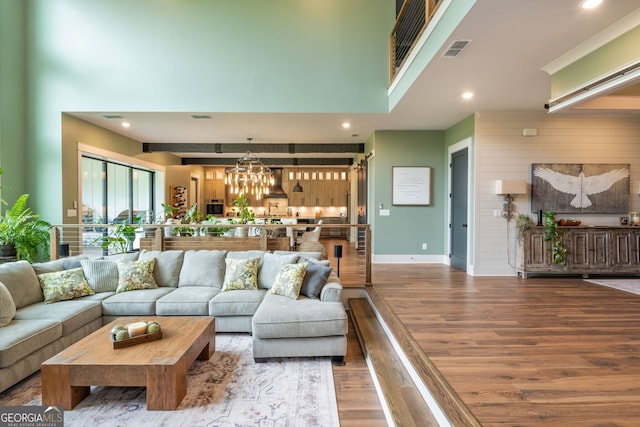 209 Voyles Way, Dawsonville, GA 30534 - living area featuring wood finished floors, a chandelier, a high ceiling, recessed lighting, and baseboards