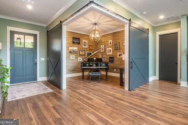 209 Voyles Way, Dawsonville, GA 30534 - foyer featuring a barn door, baseboards, wood walls, wood finished floors, and crown molding