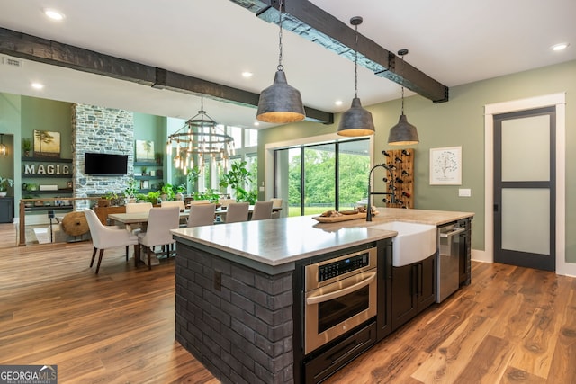 209 Voyles Way, Dawsonville, GA 30534 - kitchen featuring appliances with stainless steel finishes, beam ceiling, a sink, light countertops, and wood finished floors
