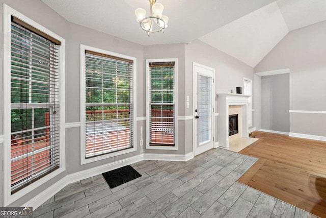 4544 Dorsett Shoals Run, Douglasville, GA 30135 - doorway featuring a chandelier, wood finished floors, a fireplace, and vaulted ceiling