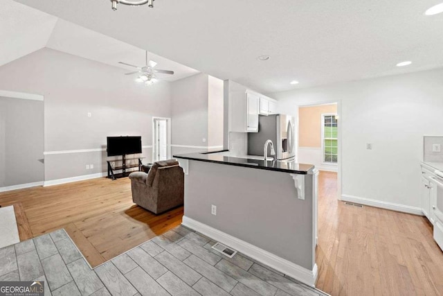4544 Dorsett Shoals Run, Douglasville, GA 30135 - kitchen with stainless steel fridge, light wood-style flooring, white cabinetry, ceiling fan, and recessed lighting