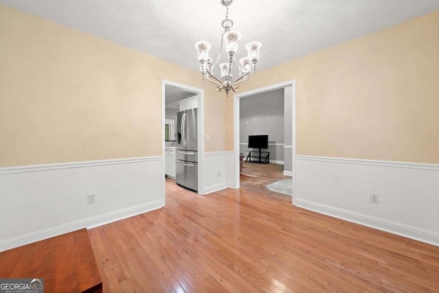 4544 Dorsett Shoals Run, Douglasville, GA 30135 - unfurnished dining area featuring a chandelier, light wood-style flooring, and wainscoting