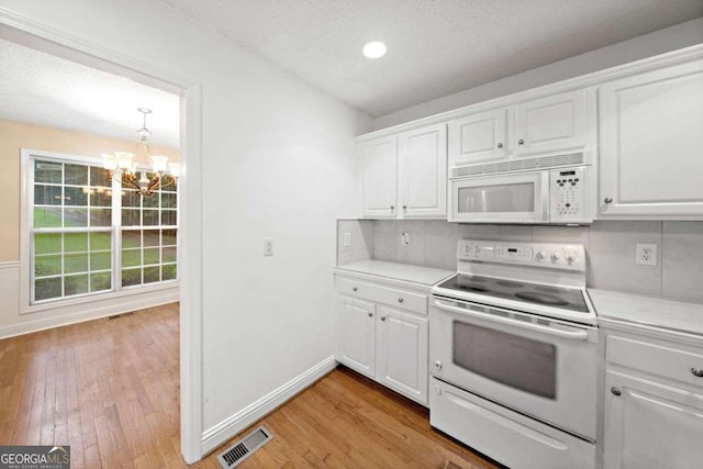 4544 Dorsett Shoals Run, Douglasville, GA 30135 - kitchen with white appliances, a chandelier, light countertops, light wood-type flooring, and white cabinets
