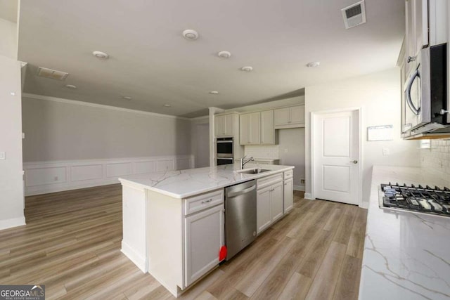 2856 Knob Creek Dr, Snellville, GA 30078 - kitchen featuring stainless steel appliances, a sink, crown molding, light wood-style floors, and light stone countertops