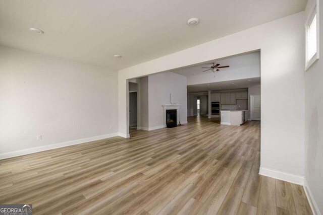 2856 Knob Creek Dr, Snellville, GA 30078 - unfurnished living room with baseboards, light wood-type flooring, a fireplace, and ceiling fan