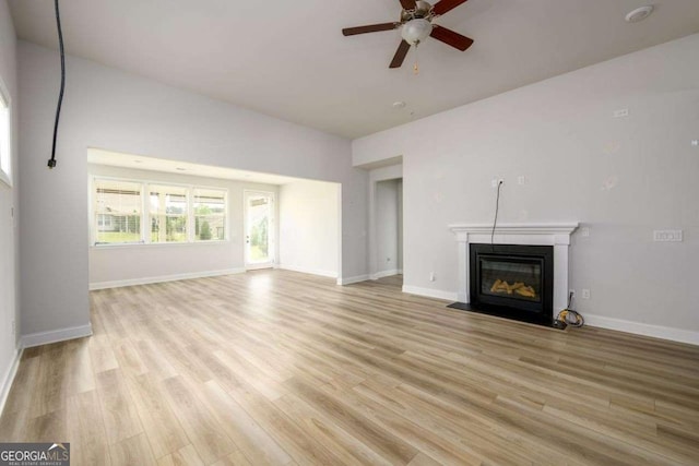 2856 Knob Creek Dr, Snellville, GA 30078 - unfurnished living room featuring a fireplace with flush hearth, light wood-style floors, ceiling fan, and baseboards
