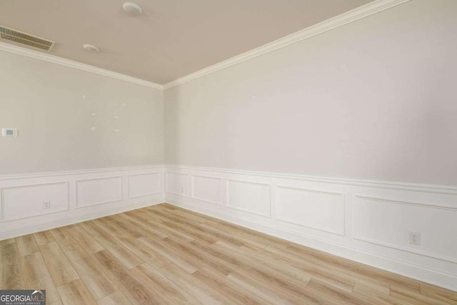 2856 Knob Creek Dr, Snellville, GA 30078 - empty room featuring ornamental molding, wainscoting, light wood-style flooring, and a decorative wall