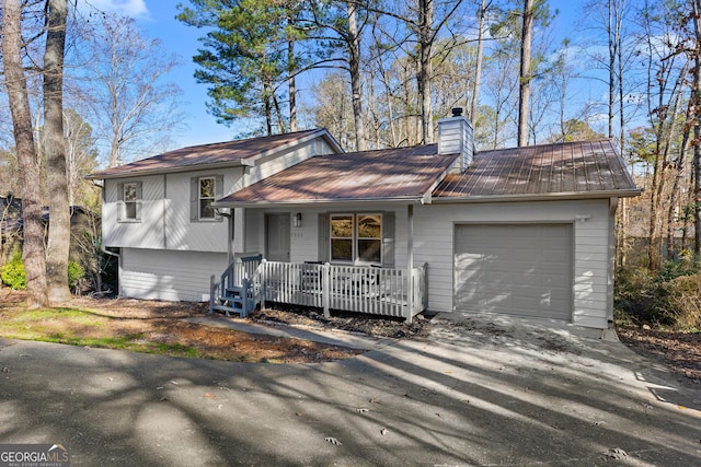 7000 Woodland Pl NW, Kennesaw, GA 30152 - tri-level home featuring a porch, an attached garage, a chimney, driveway, and a metal roof