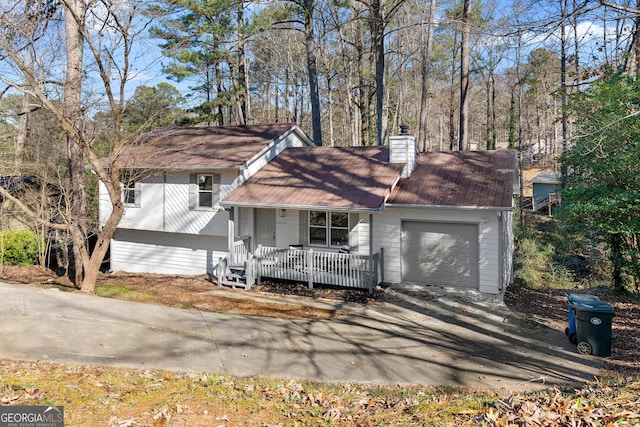 7000 Woodland Pl NW, Kennesaw, GA 30152 - tri-level home with covered porch, a chimney, driveway, and a garage