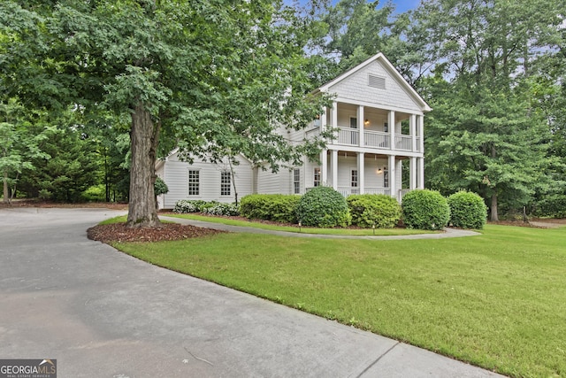 775 Markhams Dr, Madison, GA 30650 - neoclassical home featuring a balcony, a front yard, and driveway