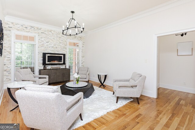 720 Latrobe Way, Macon, GA 31220 - living room with crown molding, a chandelier, light wood-style flooring, baseboards, and a stone fireplace