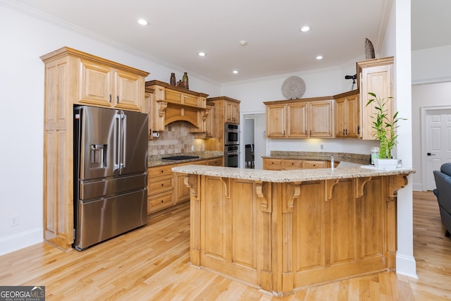 720 Latrobe Way, Macon, GA 31220 - kitchen with appliances with stainless steel finishes, a peninsula, light stone counters, light wood-type flooring, and backsplash