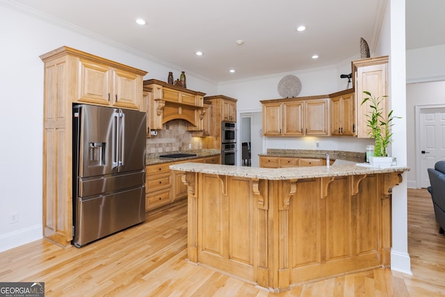 720 Latrobe Way, Macon, GA 31220 - kitchen featuring stainless steel appliances, a peninsula, light stone countertops, light wood-type flooring, and backsplash