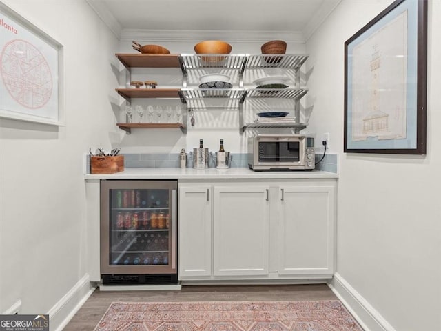 2054 Palifox Dr NE, Atlanta, GA 30307 - indoor dry bar with beverage cooler, light wood finished floors, baseboards, ornamental molding, and stainless steel microwave