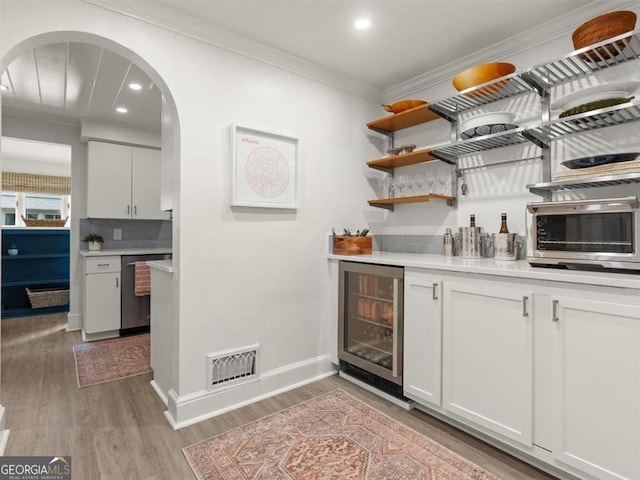 2054 Palifox Dr NE, Atlanta, GA 30307 - indoor dry bar with arched walkways, wine cooler, dishwasher, crown molding, and light wood-type flooring