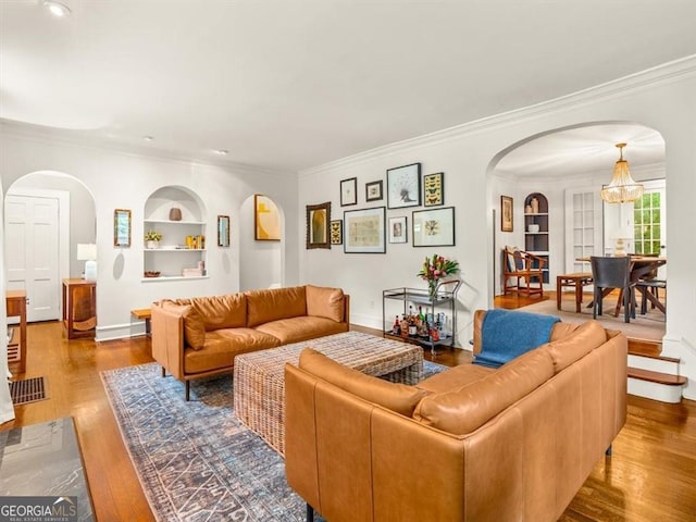 2054 Palifox Dr NE, Atlanta, GA 30307 - living area featuring built in features, arched walkways, crown molding, wood finished floors, and baseboards