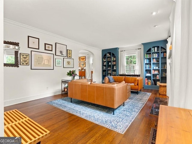 2054 Palifox Dr NE, Atlanta, GA 30307 - living room featuring arched walkways, wood finished floors, ornamental molding, baseboards, and built in shelves