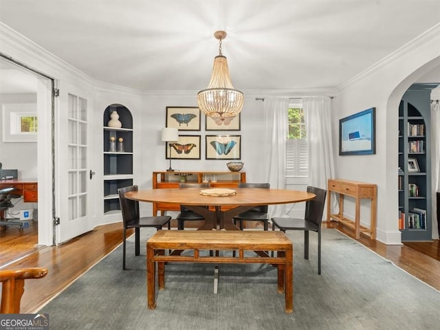 2054 Palifox Dr NE, Atlanta, GA 30307 - dining room with built in shelves, arched walkways, wood finished floors, crown molding, and a chandelier