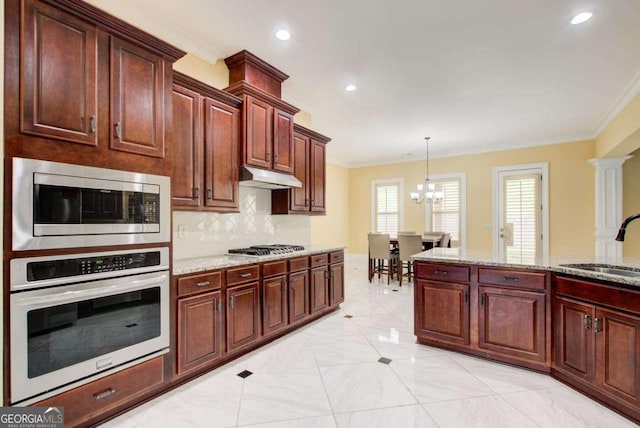 332 Warwick Pl, Mcdonough, GA 30253 - kitchen featuring stainless steel appliances, a sink, ornamental molding, tasteful backsplash, and under cabinet range hood