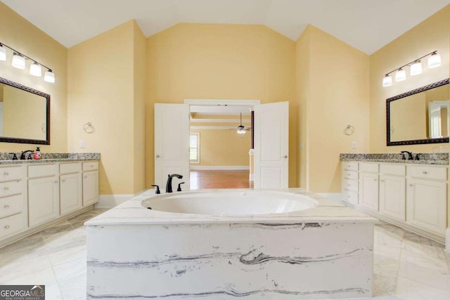 332 Warwick Pl, Mcdonough, GA 30253 - full bathroom featuring vaulted ceiling, two vanities, a garden tub, and marble finish floors