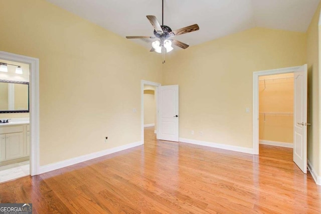 332 Warwick Pl, Mcdonough, GA 30253 - unfurnished bedroom with light wood-type flooring, lofted ceiling, ensuite bath, a walk in closet, and baseboards