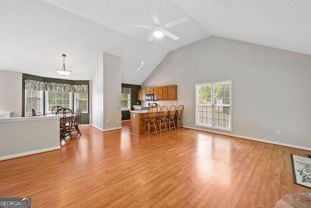 2623 Lone Oak Trl NW, Kennesaw, GA 30144 - living room featuring light wood finished floors, vaulted ceiling, a ceiling fan, and baseboards