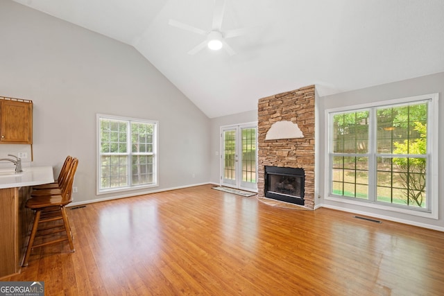 2623 Lone Oak Trl NW, Kennesaw, GA 30144 - unfurnished living room featuring a ceiling fan, high vaulted ceiling, light wood-type flooring, a fireplace, and baseboards