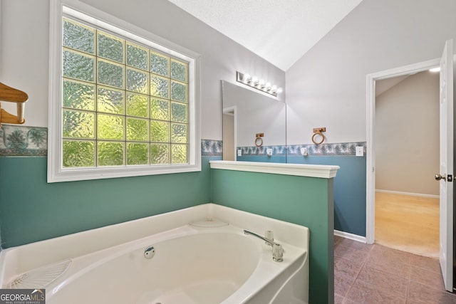 2623 Lone Oak Trl NW, Kennesaw, GA 30144 - bathroom featuring a bath, vaulted ceiling, a wainscoted wall, and tile patterned flooring