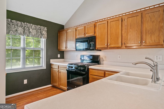 2623 Lone Oak Trl NW, Kennesaw, GA 30144 - kitchen featuring black appliances, a sink, light countertops, light wood-style floors, and vaulted ceiling