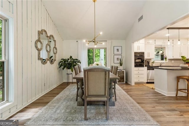171 N Trce, Alpharetta, GA 30009 - dining room featuring light wood-style flooring, a chandelier, and lofted ceiling