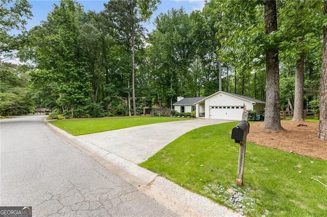 171 N Trce, Alpharetta, GA 30009 - view of front of property with concrete driveway, a front yard, an attached garage, and view of wooded area