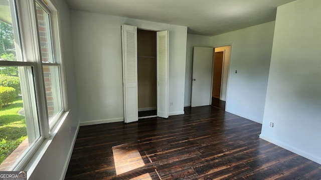 766 Virginia Cir, Forest Park, GA 30297 - unfurnished bedroom featuring wood finished floors, multiple windows, baseboards, and a closet