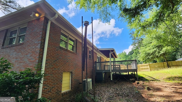 766 Virginia Cir, Forest Park, GA 30297 - view of home's exterior featuring a wooden deck, brick siding, and central AC unit