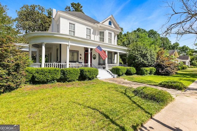 416 Engram St, Montezuma, GA 31063 - view of front facade with a porch, a front lawn, and a chimney