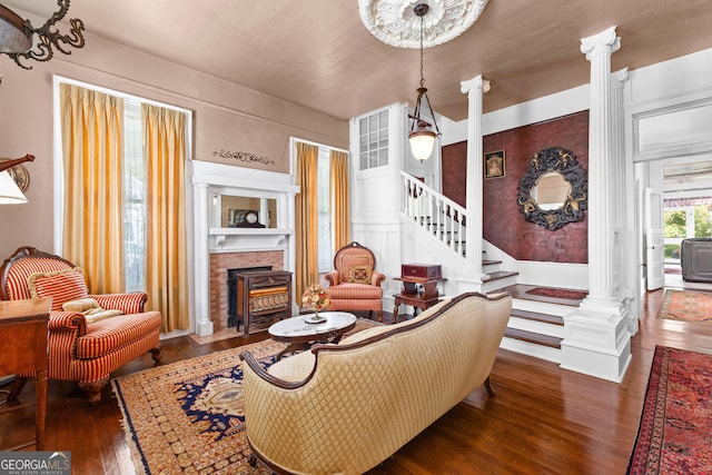 416 Engram St, Montezuma, GA 31063 - living area with hardwood / wood-style flooring, a brick fireplace, stairs, and ornate columns