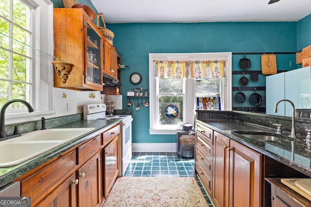 416 Engram St, Montezuma, GA 31063 - kitchen with white electric stove, a sink, under cabinet range hood, and healthy amount of natural light