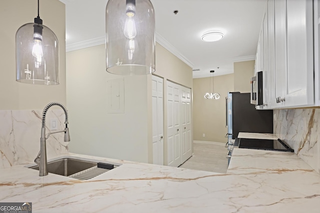 2499 Peachtree Rd Unit 506, Atlanta, GA 30305 - kitchen featuring stainless steel appliances, white cabinets, light stone counters, crown molding, and pendant lighting