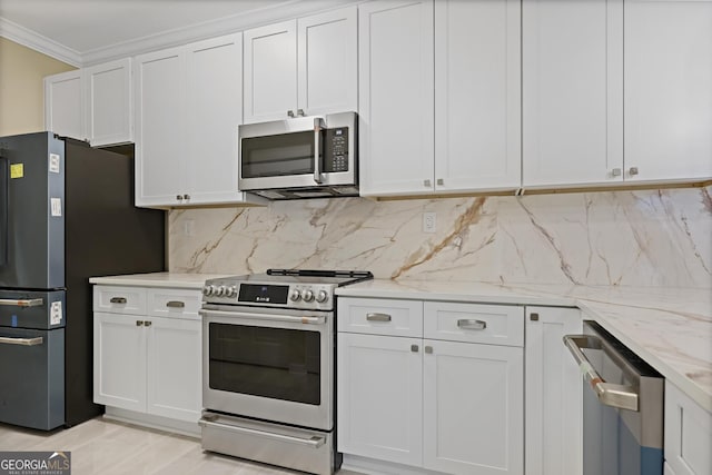 2499 Peachtree Rd Unit 506, Atlanta, GA 30305 - kitchen featuring stainless steel appliances, ornamental molding, light stone counters, white cabinetry, and tasteful backsplash