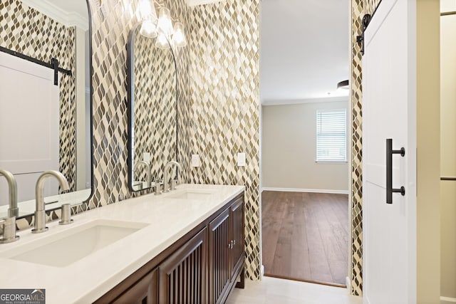 2499 Peachtree Rd Unit 506, Atlanta, GA 30305 - bathroom featuring crown molding, wallpapered walls, double vanity, wood-type flooring, and a chandelier