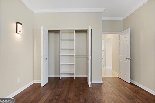 2499 Peachtree Rd Unit 506, Atlanta, GA 30305 - unfurnished bedroom with ornamental molding, dark wood-style flooring, arched walkways, and a closet