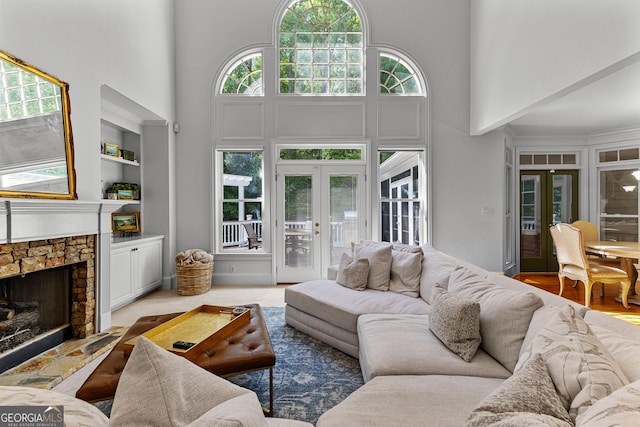 220 Broadmoor Dr, Fayetteville, GA 30215 - living room featuring french doors, a high ceiling, built in features, and a stone fireplace