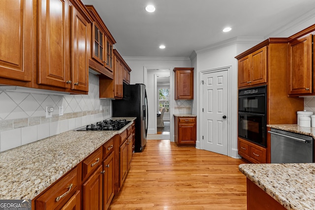 220 Broadmoor Dr, Fayetteville, GA 30215 - kitchen featuring black appliances, light wood finished floors, crown molding, recessed lighting, and brown cabinets