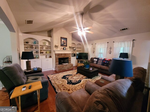 135 Pine Creek Way, Winterville, GA 30683 - living room featuring built in features, wood finished floors, vaulted ceiling, and a brick fireplace