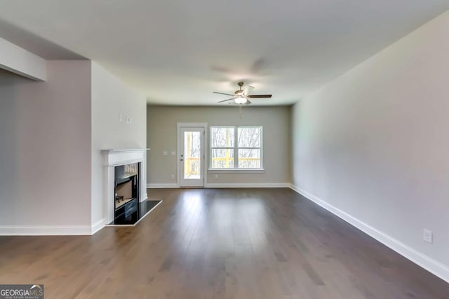 37 Radian Way, Dallas, GA 30132 - unfurnished living room with ceiling fan, a fireplace with raised hearth, dark wood-type flooring, and baseboards