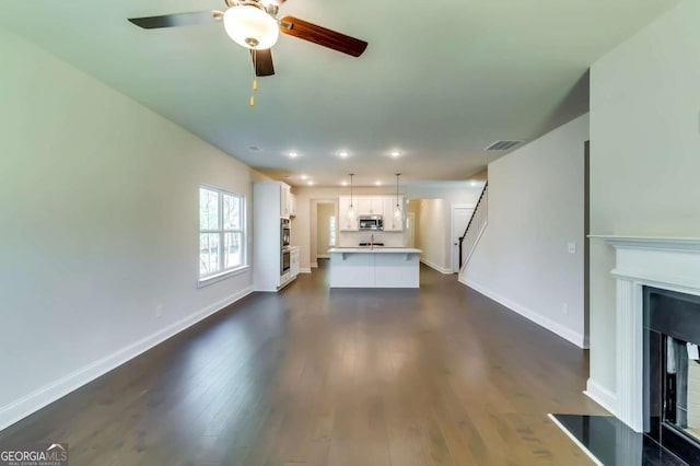 37 Radian Way, Dallas, GA 30132 - unfurnished living room featuring baseboards, ceiling fan, dark wood finished floors, a fireplace with raised hearth, and recessed lighting