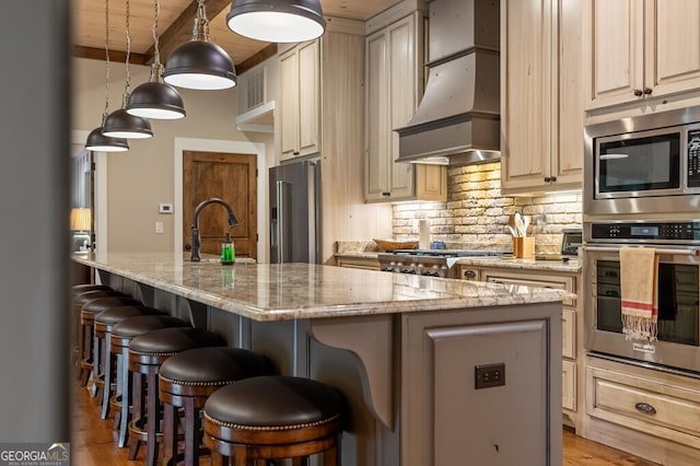 547 Toccoa River Ln, Mineral Bluff, GA 30559 - kitchen featuring stainless steel appliances, custom range hood, a kitchen island with sink, a sink, and light stone counters
